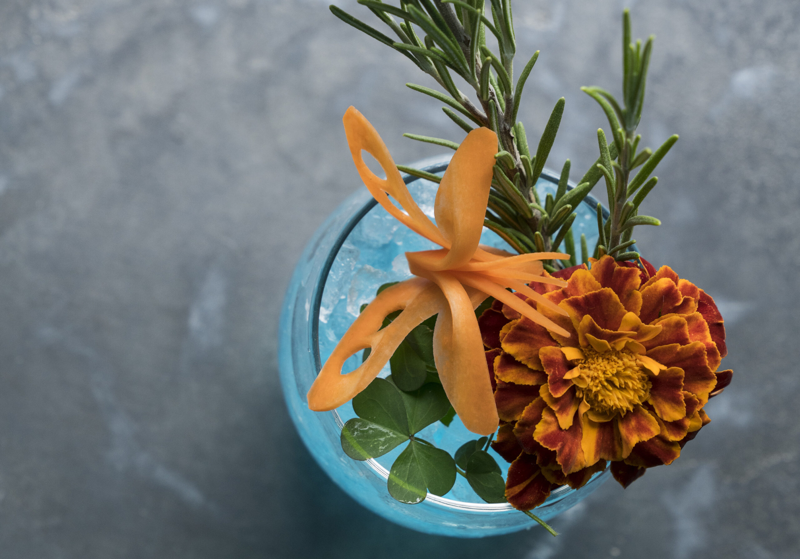 Gintonic mit Blumen dekoriert, Rosmarin, Kleebläter als Zierde