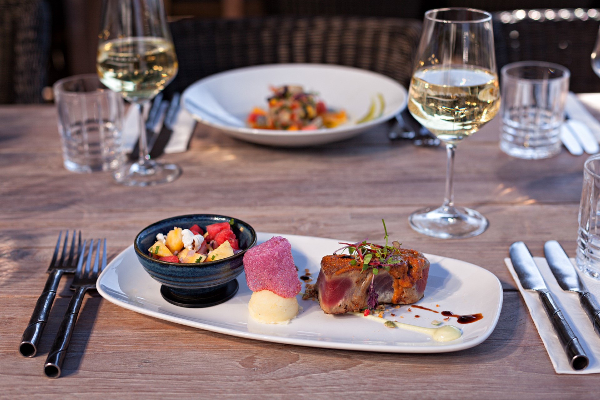 Restaurant Meerbar angerichteter Tisch mit Speise und Weißwein